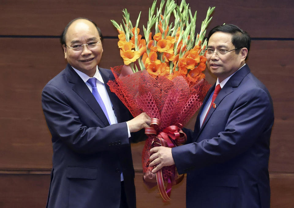 Vietnamese newly elected President Nguyen Xuan Phuc, left, and newly elected Prime Minister Pham Minh Chinh pose for a photo in the National Assembly in Hanoi, Vietnam on Monday, April 5, 2021. Vietnam's legislature voted Monday to make Pham Minh Chinh, a member of the Communist party's central committee for personnel and organization, the country's next prime minister. Outgoing Prime Minister Nguyen Xuan Phuc was appointed the new president. (Hoang Thong Nhat/VNA via AP)