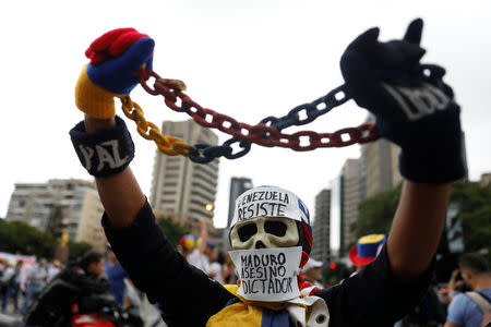 A demonstrator wears a mask reading: 'Resists Venezuela, Maduro murderer, dictator' while rallying against Venezuela's President Nicolas Maduro in Caracas, Venezuela May 1, 2017. REUTERS/Carlos Garcia Rawlins