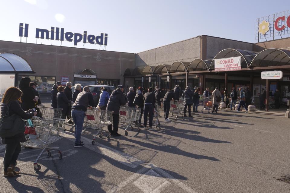 People queue outside a supermarket in Casalpusterlengo, Northern Italy, Monday, Feb. 24, 2020. Italy scrambled to check the spread of Europe's first major outbreak of the new viral disease amid rapidly rising numbers of infections and a third death. Road blocks were set up in at least some of 10 towns in Lombardy at the epicenter of the outbreak, including in Casalpusterlengo, to keep people from leaving or arriving. (AP Photo/Paolo Santalucia)