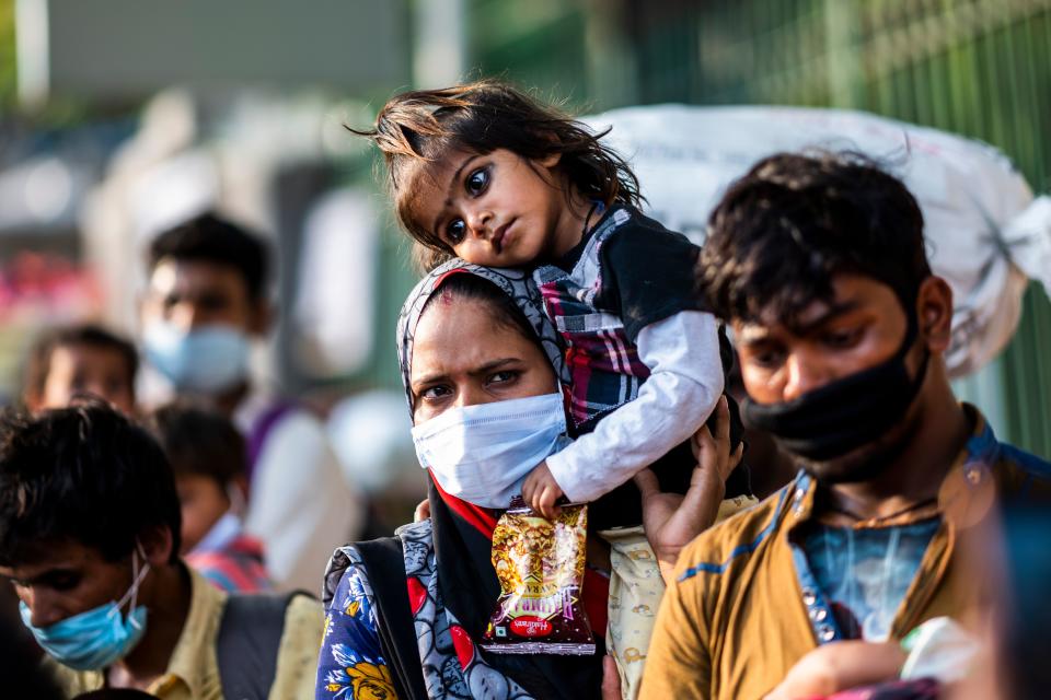 A migrant worker mother carries her daughter on her shoulder as she walks along a street during a nationwide lockdown imposed as a preventive measure against the spread of the COVID-19 coronavirus in New Delhi on May 13, 2020. (Photo by Jewel SAMAD / AFP) (Photo by JEWEL SAMAD/AFP via Getty Images)