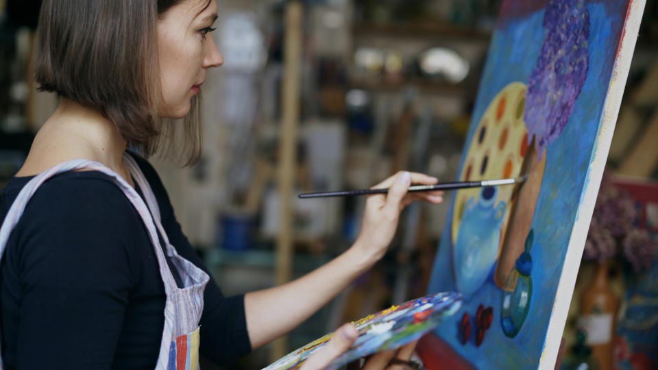 Young artist woman painting still life picture on canvas in art-school (Getty Images)