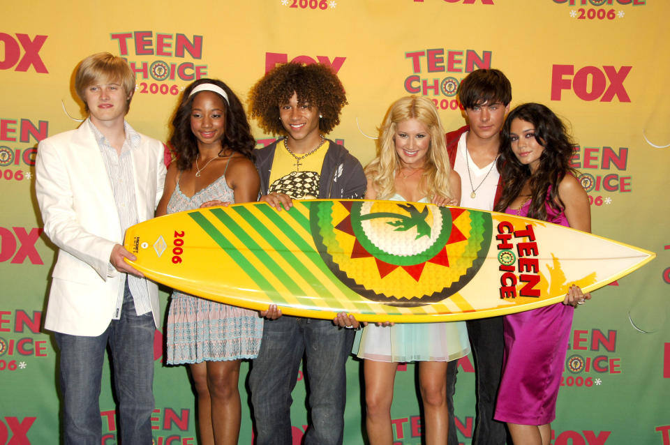 With other cast members, holding up a "Teen Choice" surfboard