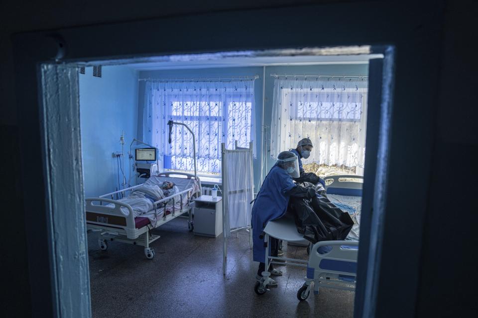 FILE - A medical worker prepares to transport the body of a COVID-19 victim at a hospital in Kakhovka, Ukraine, on Oct. 29, 2021. The World Health Organization said Friday May 5, 2023 that COVID-19 no longer qualifies as a global emergency, marking a symbolic end to the devastating coronavirus pandemic that triggered once-unthinkable lockdowns, upended economies and killed millions of people worldwide. (AP Photo/Evgeniy Maloletka, File)