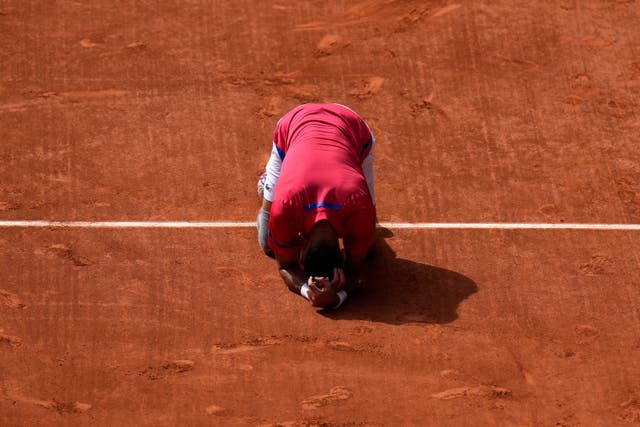 Novak Djokovic drops to his knees on the court 