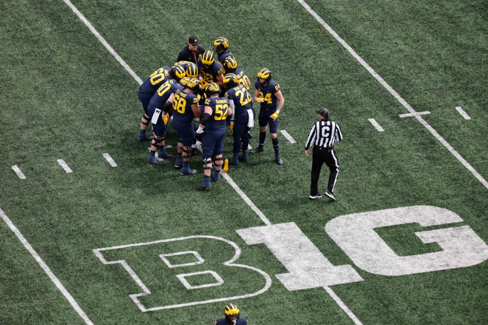 April 2, 2022; Ann Arbor; Michigan Wolverines head coach Jim Harbaugh listens in as quarterback <a class="link " href="https://sports.yahoo.com/ncaaf/players/286629" data-i13n="sec:content-canvas;subsec:anchor_text;elm:context_link" data-ylk="slk:Alan Bowman;sec:content-canvas;subsec:anchor_text;elm:context_link;itc:0">Alan Bowman</a> (15) huddles up the offense during the Spring game at Michigan Stadium. Rick Osentoski-USA TODAY Sports