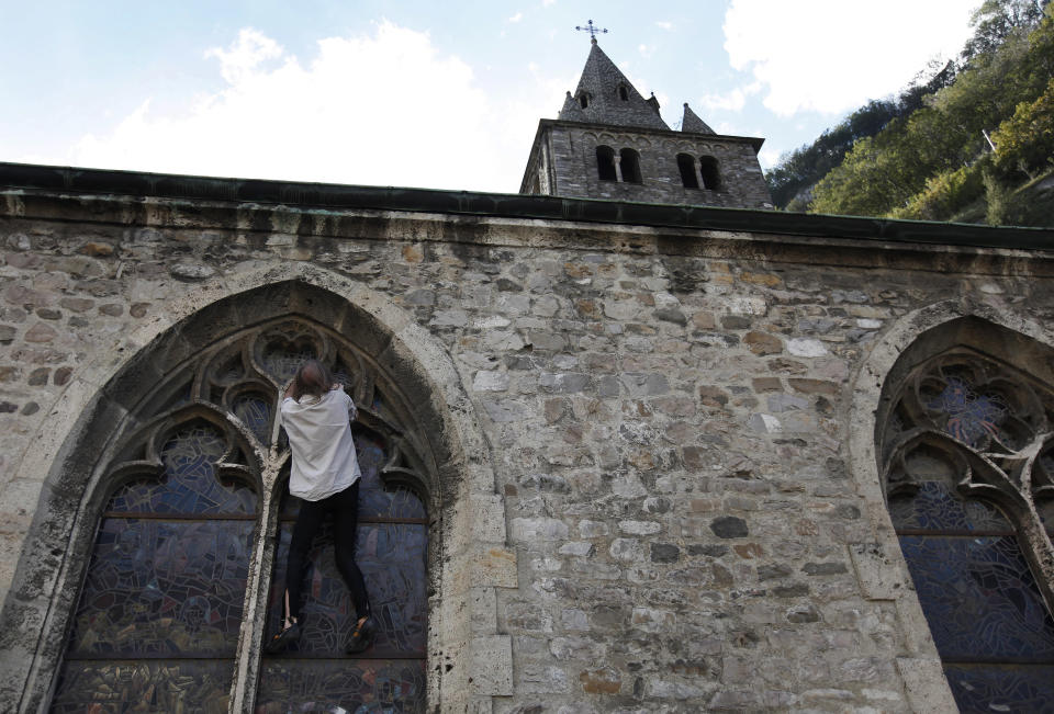 French climber Alain Robert, also known as "Spiderman", climbs on a stained glass window of the Abbey during a recce climb in St-Maurice October 3, 2012. Robert will attempt to climb the church on October 5, 2012 after a conference. REUTERS/Denis Balibouse