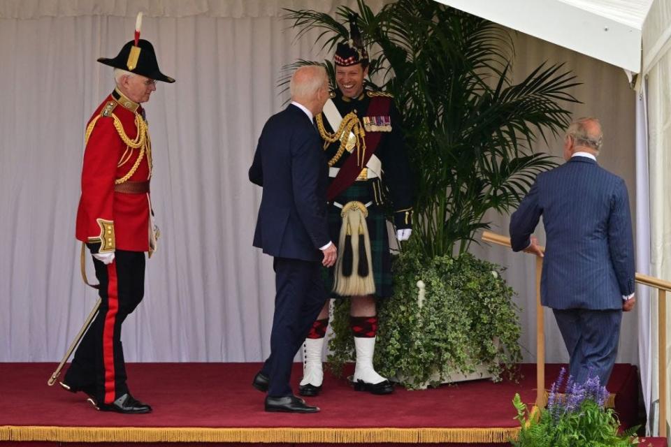 President Joe Biden jokes with King Charles' equerry