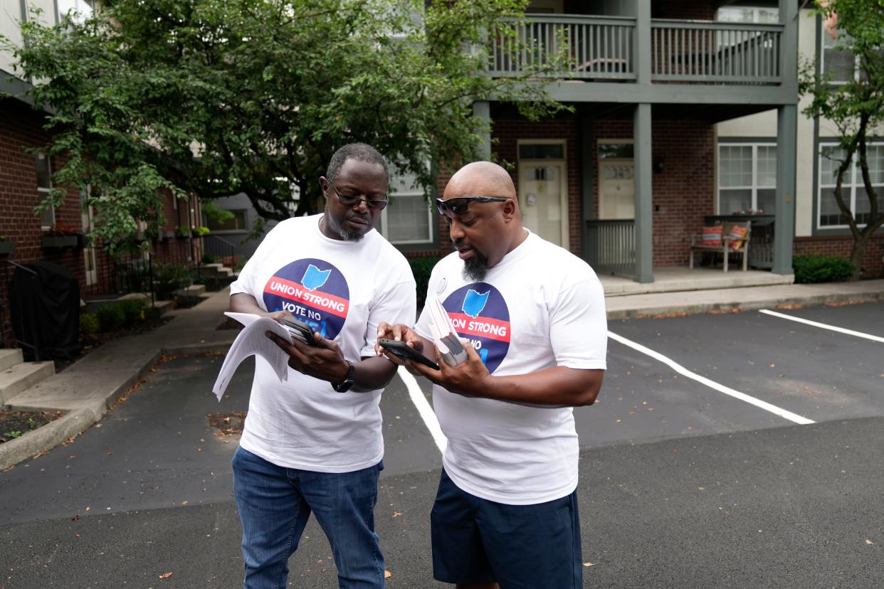 Jarvis Williams, left, of Pickerington and Tyson Brown of the North Side knock on doors in Grandview Heights to spread information about voting against Issue 1 in the August special election. 
(Credit: Adam Cairns/Columbus Dispatch)