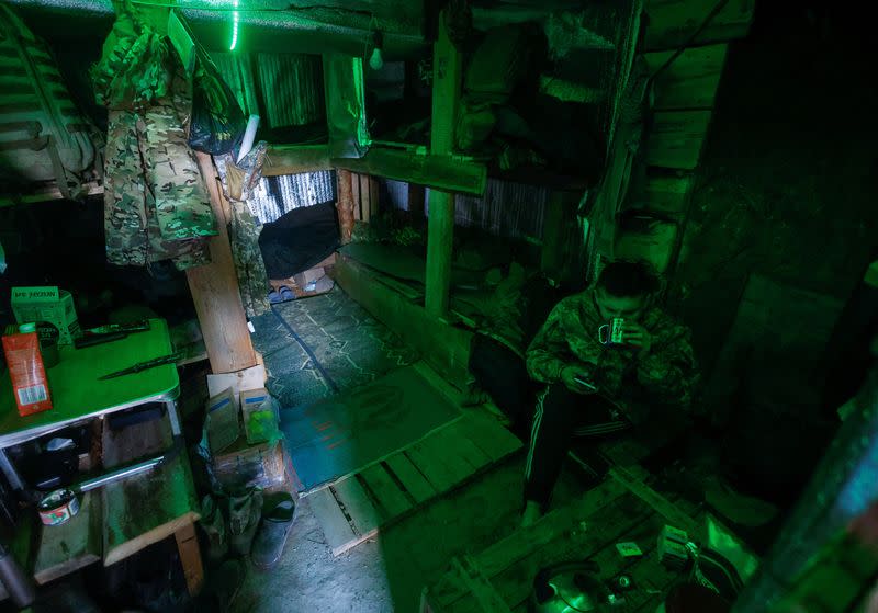 Ukrainian serviceman drinks tea inside a dugout at a position in a frontline in Mykolaiv region