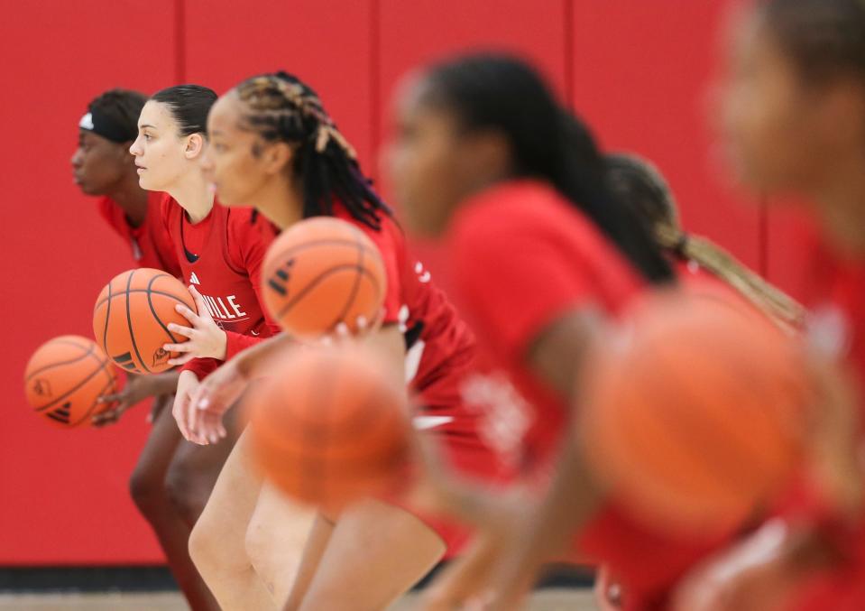 Louisville freshman center Eseosa Imafidon, far left, and freshman Elif Istanbulluoglu prepare to work on a passing drill during practice for the upcoming 2023-24 season. Imafidon is 6-5 center from Nigeria; Istanbullouglu is from Turkey. Oct. 31, 2023.