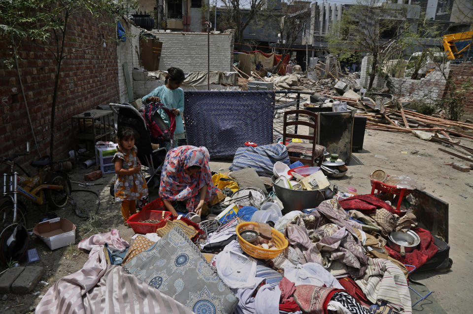 A family collects salvages belongings from their damaged houses at the site of a car bombing Wednesday, in Lahore, Pakistan, Thursday, June 24, 2021. Pakistani security forces on Thursday arrested one of the alleged perpetrators of the car bombing that killed at least three people and wounded some 25 others near the residence of a jailed anti-India militant leader Hafiz Saeed, in the eastern city of Lahore, officials said. (AP Photo/K.M. Chaudary)