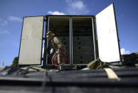 A member of the US army reserve works to set up up portable showers in a tent city for hundreds of people displaced by earthquakes in Guanica, Puerto Rico, Tuesday, Jan. 14, 2020. A 6.4 magnitude quake that toppled or damaged hundreds of homes in southwestern Puerto Rico is raising concerns about where displaced families will live, while the island still struggles to rebuild from Hurricane Maria two years ago. (AP Photo/Carlos Giusti)