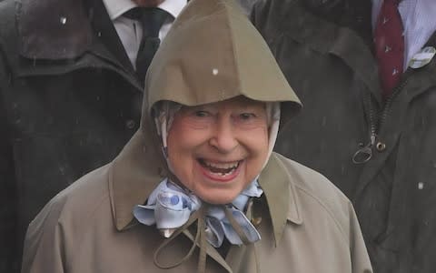 A hooded Queen Elizabeth II smiles at the Royal Windsor Horse Show - Credit: James Whatling