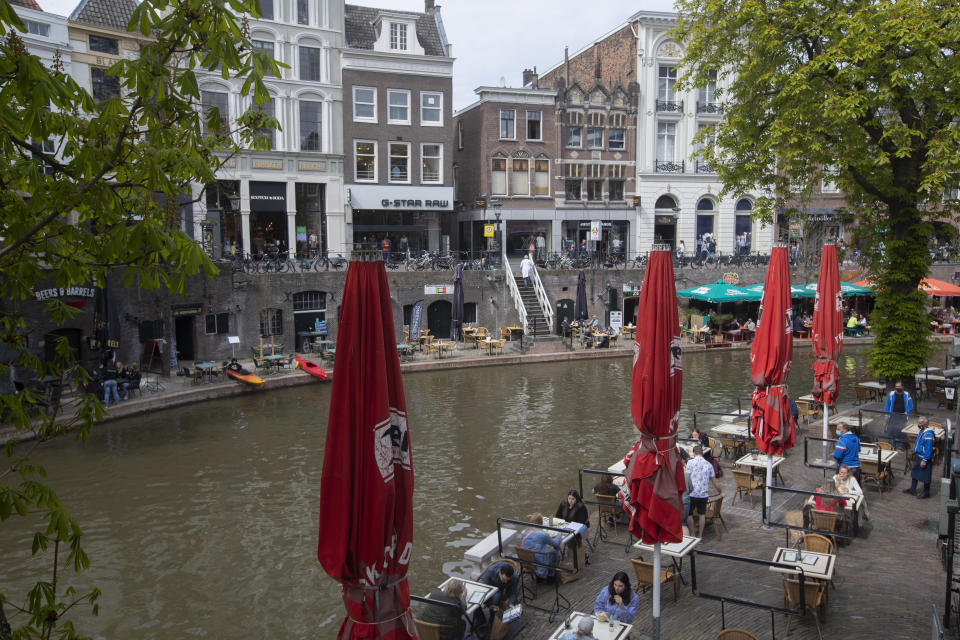 Ansiosos por tomar su primer café o algo más fuerte, los holandeses acuden a terrazas al aire libre al relajarse las restricciones nacionales por el coronavirus en Utrecht, Holanda, el miércoles 28 de abril de 2021. (AP Foto/Peter Dejong)