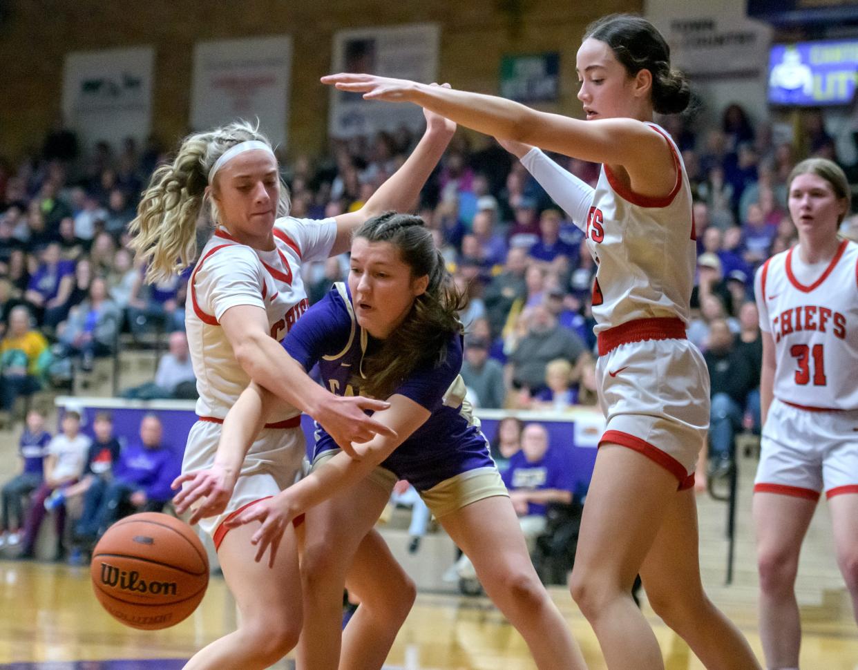 Canton's Allison Wheeler passes the ball under pressure from Dee-Mack's Mackenzie Knowles, left, and Dalia DeJesus in the first half of their Class 2A girls basketball sectional semifinal Tuesday, Feb. 20, 2024 at Ingersoll Gym in Canton. The Chiefs advanced to the final with a 44-34 win over the Little Giants.