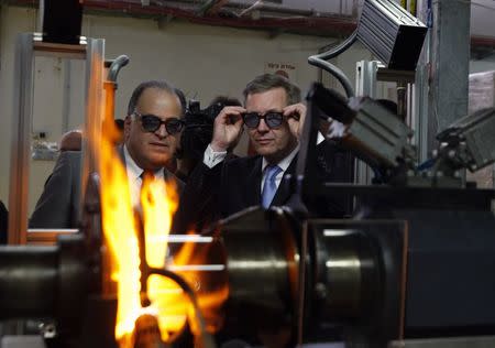 Germany's then-President Christian Wulff (R) and Avi Brenmiller, CEO of Siemens' solar receiver production plant, wear protective glasses during a visit to the plant in Beit Shemesh in this November 29, 2010 file photo. REUTERS/Amir Cohen/Files