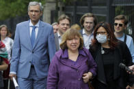 Belarusian Svetlana Alexievich, the 2015 Nobel literature laureate, center, and Pavel Latushko, former culture minister and Belarusian Ambassador to France, left, walk surrounded by supporters and journalists on their way to the Belarusian Investigative Committee in Minsk, Belarus, Wednesday, Aug. 26, 2020. Members of the opposition's Coordination Council, as Pavel Latushko and Svetlana Alexievich, have been summoned for questioning over the protests in an apparent attempt by authorities to intimidate them. (AP Photo/Sergei Grits)