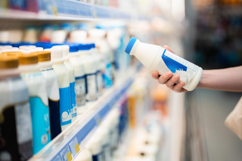 Close up shot of woman holding a bottle of organic fresh milk in supermarket. The expert says full-fat dairy can be a great addition to a healthy diet. (Getty)