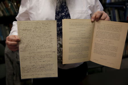 Roni Gross, curator of the Hebrew University's Albert Einstein Archive, displays original documents related to Albert Einstein's hypothesis of the existence of gravitational waves during a news conference in Jerusalem February 11, 2016. REUTERS/Ronen Zvulun