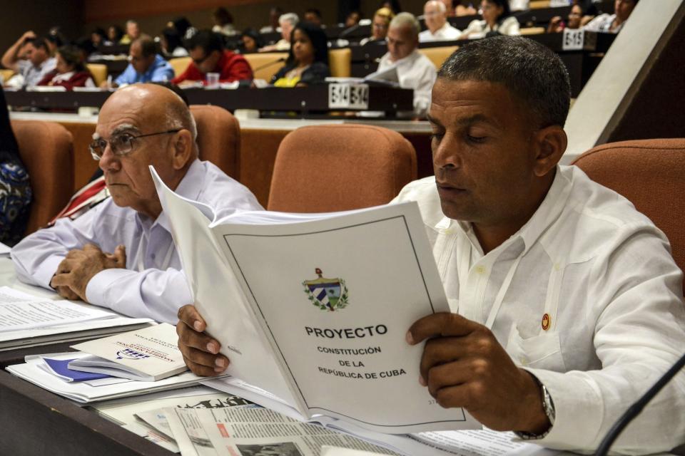 FILE - In this July 21, 2018 photo, a member of the National Assembly studies the proposed constitutional update in Havana, Cuba. Some observers see the new constitution as a merely cosmetic update aimed at assuring one of the world’s last communist systems won’t get another revamp until long after the passing of its founding fathers, while others see the potential for a slow-moving but deep set of changes that will speed the modernization of Cuba’s economically stagnant authoritarian bureaucracy. (Abel Padron, Agencia Cubana de Noticias via AP, File)