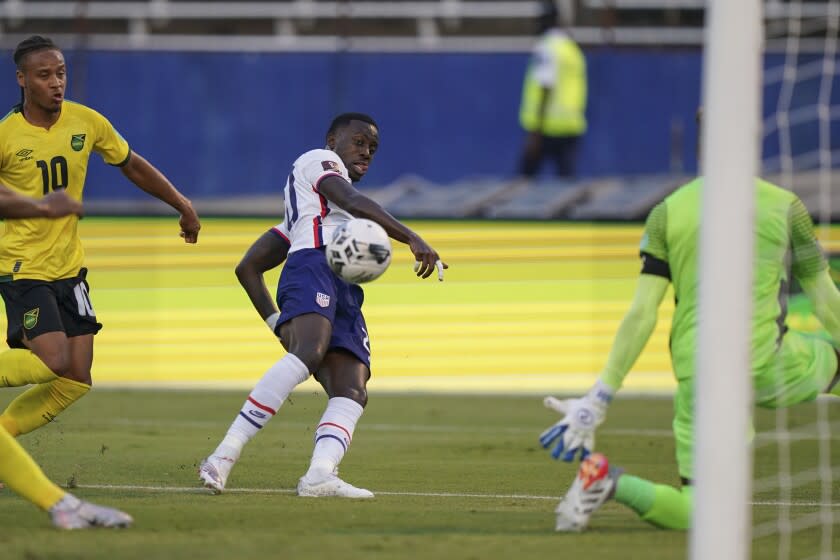 United States' Tim Weah, center, scores his side's opening goal against Jamaica during a qualifying soccer match for the FIFA World Cup Qatar 2022 in Kingston, Jamaica, Tuesday, Nov. 16, 2021. (AP Photo/Fernando Llano)