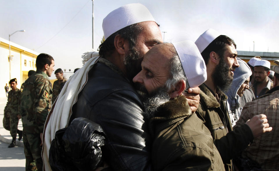 FILE - In this Friday, Jan. 4, 2013 file photo, Afghan men hug each other after being released from prison in Kabul, Afghanistan, some of 250 prisoners formerly held by the U.S. The released prisoners had been captured in operations against the Taliban and other groups. Secret contacts are again reported to be underway for an Afghanistan peace deal, but neither analysts nor the belligerents see hope they will succeed. (AP Photo/Ahmad Jamshid, File)