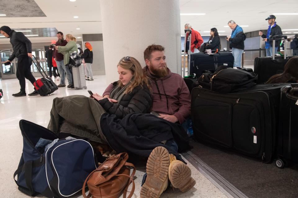 Kelli Jones leans against James Heyburn, of Florida, as the two wait for a rental car to be ready after their flight with Southwest Airlines had been canceled at Nashville International Airport on Tuesday.