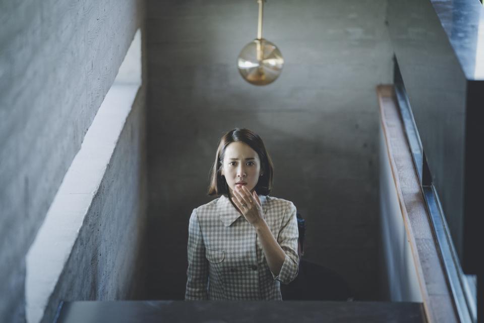 A woman looks shocked while coming upstairs