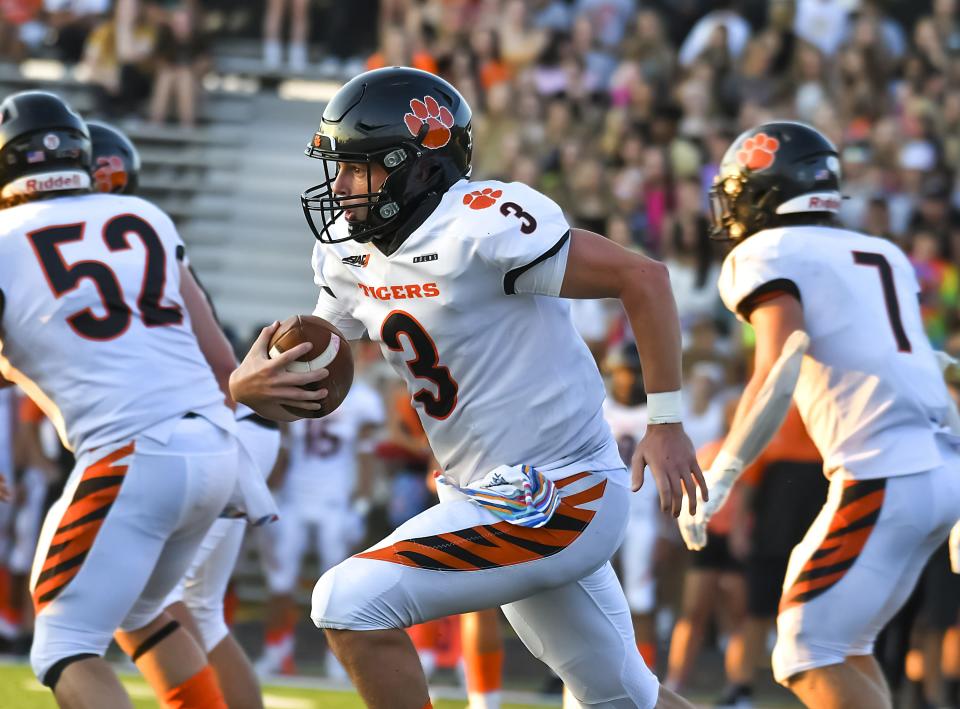 Lawrenceburg quarterback Logan Ahaus runs the ball against East Central during the Skyline Chili Crosstown Showdown at East Central High School on Friday, Aug. 19, 2022.