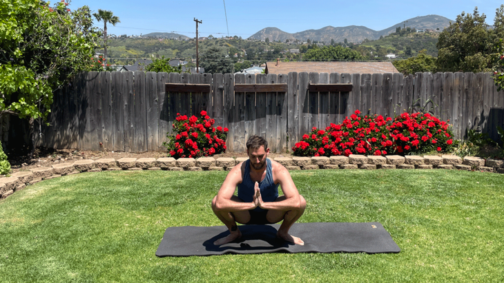 Man on a yoga mat outside in his back yard practicing yoga for tall people