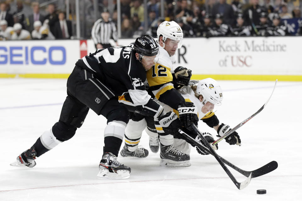 Los Angeles Kings' Trevor Lewis, left, is defended by Pittsburgh Penguins' Patrick Marleau, center, and Juuso Riikola during the second period of an NHL hockey game Wednesday, Feb. 26, 2020, in Los Angeles. (AP Photo/Marcio Jose Sanchez)