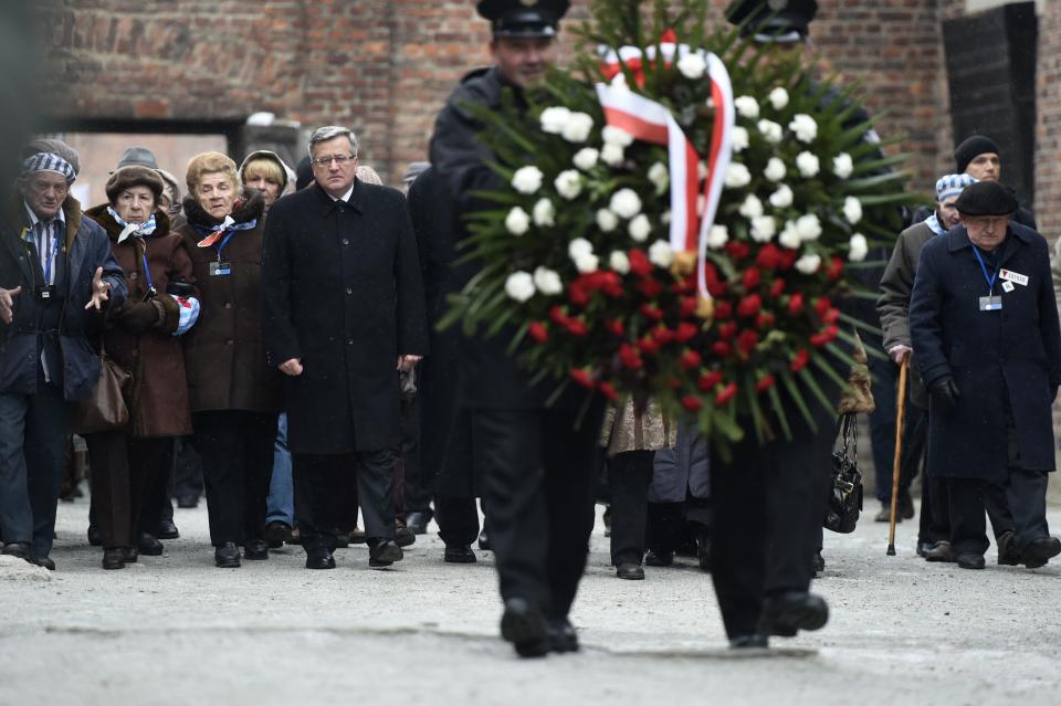 Polish President Bronislaw Komorowski (C) and Auschwitz survivors lay down a wreath at the death wall of the former Auschwitz concentration camp on January 27, 2015 at the Auschwitz-Birkenau memorial site in Oswiecim, Poland. Seventy years after the liberation of Auschwitz, ageing survivors and dignitaries gather at the site synonymous with the Holocaust to honour victims and sound the alarm over a fresh wave of anti-Semitism. 