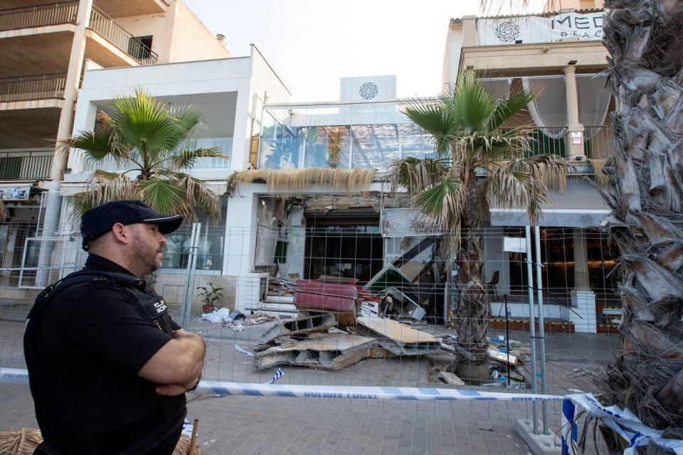 A police officer stands during investigation works one day after a two-storey restaurant collapsed (AFP via Getty Images)