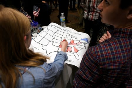 FILE PHOTO: A girls colors an electoral map of the United States in either red or blue in Raleigh, North Carolina, U.S.