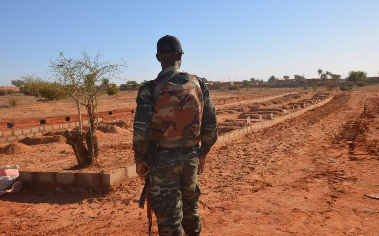 A Nigerien soldier looks at the graves of the soldiers killed in attacks from jihadists in December. Two devastating attacks on army bases in the West of the country killed over 150 soldiers, leaving Niger shaken to its core.  - Boureima Hama/AFP
