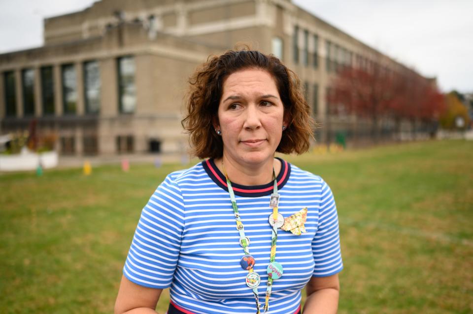 Samantha Sommer, 45, a social studies teacher at the Greenfield School, stands in front of the school after an unveiling of commemorative art project on Wednesday, Oct. 25, 2023, in Pittsburgh's Greenfield neighborhood.