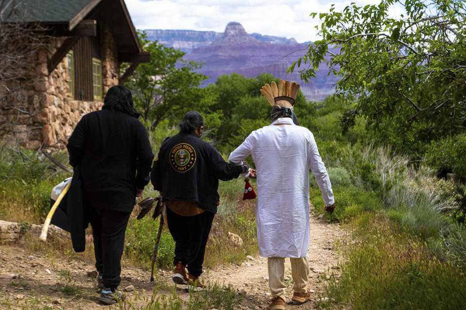 FILE - Members of the Havasupai Tribe walk down to a popular campground at Grand Canyon National Park, May 5, 2023. The tribe held a blessing ceremony to mark the renaming of the campground from Indian Garden to Havasupai Gardens. When the Grand Canyon became a national park over a century ago, many Native Americans who called it home were displaced. In 2023, meaningful steps were taken to address the federal government's actions. For one tribe, the Havasupai, the changes started this spring with a ceremony to rename a popular campground in the inner canyon from Indian Garden to Havasupai Gardens or “Ha’a Gyoh.” (AP Photo/Ty O'Neil, File)