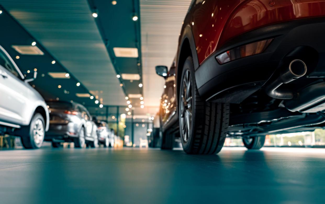 Rearview of parked cars Car dealership office. New car parked in modern showroom. Automobile leasing and insurance concept.