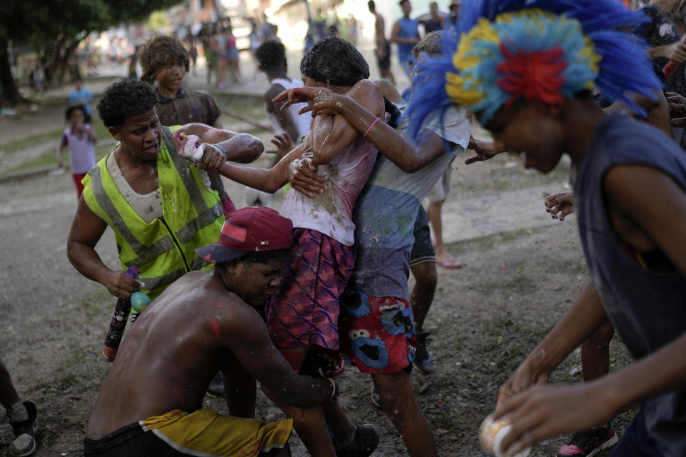 Fiesteros participan en los "juegos de agua", que convierten espacios públicos en animados campos de batalla como parte de la tradición del Carnaval, en el vecindario de Pinto Salinas, en Caracas, Venezuela, el 13 de febrero de 2024. (AP Foto/Matías Delacroix)