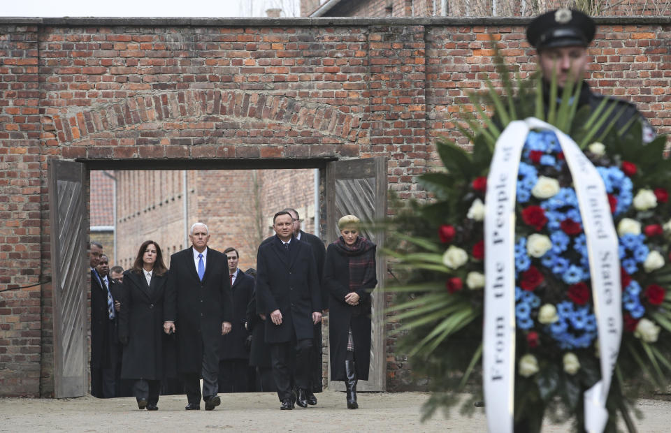 United States Vice President Mike Pence and his wife Karen Pence, left, walk with Poland's President Andrzej Duda and his wife Agata Kornhauser-Duda, right, to lay wreaths at a death wall during their visit at the Nazi concentration camp Auschwitz-Birkenau in Oswiecim, Poland, Friday, Feb. 15, 2019. (AP Photo/Michael Sohn)