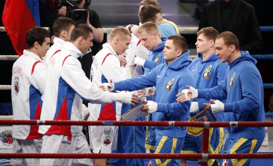 Athletes from the Russian Boxing Team, left, and Ukraine Otamans, right, greet each other, prior to their World Series of Boxing first leg quarterfinal bouts, in Moscow, Russia, Monday, March, 31, 2014. Second leg matches will take part in Donetsk, Ukraine, on April 4. (AP Photo/Denis Tyrin)