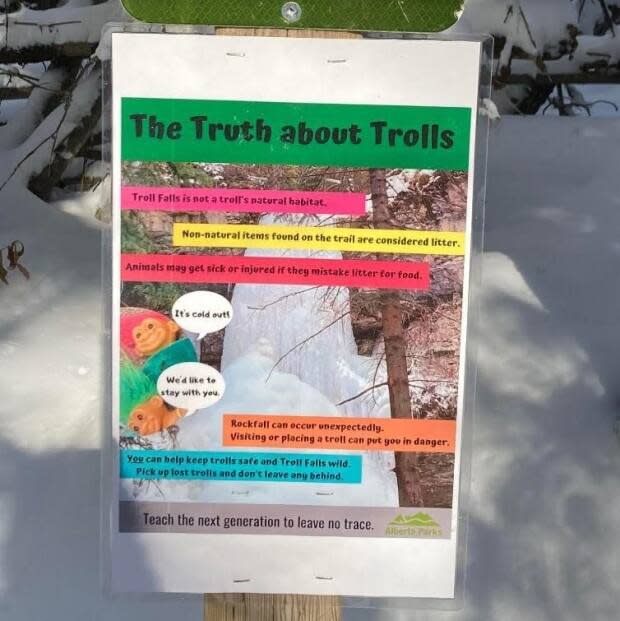 'Troll Falls is not a troll's natural habitat,' explain the kid-friendly signs posted by Alberta Parks at the popular short hike in Kananaskis. Hundreds of the wild-haired plastic toys have been hidden in the area in the past few years by hikers. (Friends of Kananaskis Country Facebook page - image credit)