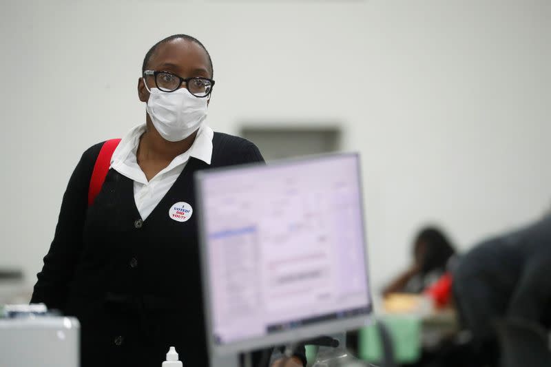 A person wearing a "I voted! Did you?" sticker looks on as votes continue to be counted at the TCF Center the day after the 2020 U.S. presidential election, in Detroit, Michigan