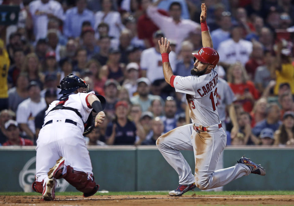 FILE - In this Aug. 16, 2017, file photo, St. Louis Cardinals' Matt Carpenter, right, tries unsuccessfully to avoid a tag by Boston Red Sox catcher Christian Vazquez during the second inning of a baseball game in Boston. The Cardinals and the Red Sox would have had one of their rare regular-season series this week. They have met in four different World Series. They would have played a three-game series at Fenway Park this week if not for the coronavirus pandemic. (AP Photo/Charles Krupa, File)