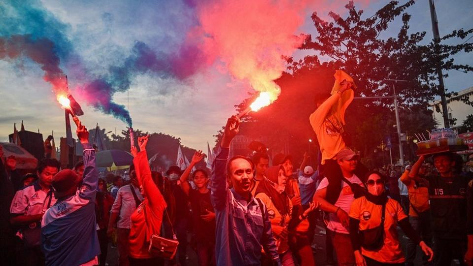 Demonstrators light flares during a rally to mark International Labour Day in Surabaya, Indonesia.