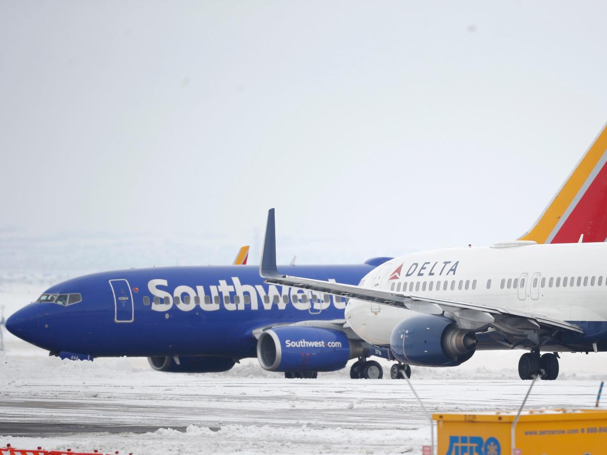 A Delta Airlines jetliner waits for a Southwest jetliner to taxi pst on the way to a runway for take off from Denver International Airport as travelers deal with the spread of coronavirus Friday, March 20, 2020, in Denver. According to the World Health Organization, most people recover in about two to six weeks depending on the severity of the COVID-19 illness. (AP Photo/David Zalubowski)