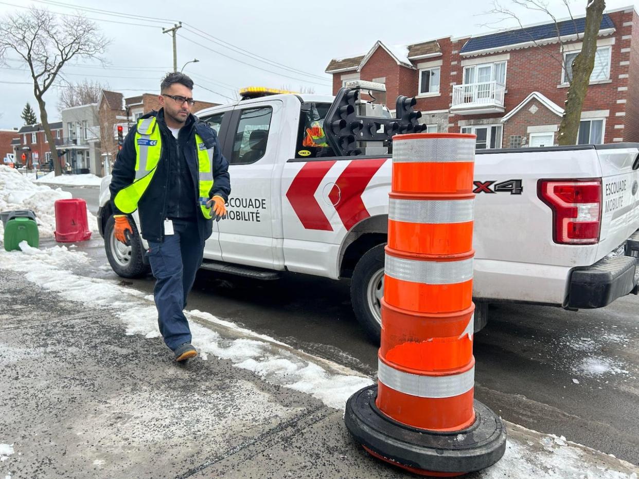 A member of Montreal's Mobility Squad inspects a site blocked by construction cones.  (Rowan Kennedy/CBC - image credit)