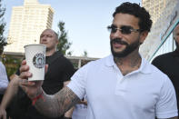 Russian singer and entrepreneur Timur Yunusov, better known as Timati, poses in front of a newly opened Stars Coffee coffee shop in the former location of the Starbucks coffee shop in Moscow, Russia, Thursday, Aug. 18, 2022. A new chain of coffee shops opens Thursday in Moscow, after Russian singer and entrepreneur Timur Yunusov, better known as Timati, together with Russian restaurateur Anton Pinskiy bought the Starbucks stores following company's withdrawal from Russia. (AP Photo/Dmitry Serebryakov)