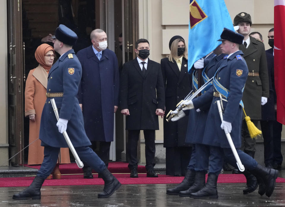 Ukrainian President Volodymyr Zelenskyy, centre, his wife Olena, centre right, Turkey's President Recep Tayyip Erdogan, centre left, accompanied by his wife Emine, left, review the honour guard during a welcome ceremony ahead of their meeting in Kyiv, Ukraine, Thursday, Feb. 3, 2022. (AP Photo/Efrem Lukatsky)