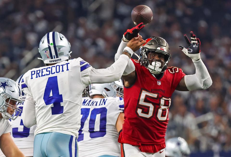 Dallas Cowboys quarterback Dak Prescott (4) hits his hand against Tampa Bay Buccaneers linebacker Shaquil Barrett (58) as he throws the ball during the fourth quarter at AT&T Stadium.